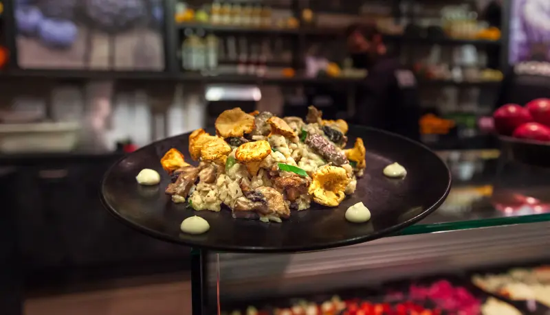 Bord met een gerecht met cantharellen en andere paddenstoelen op de toonbank van Kors